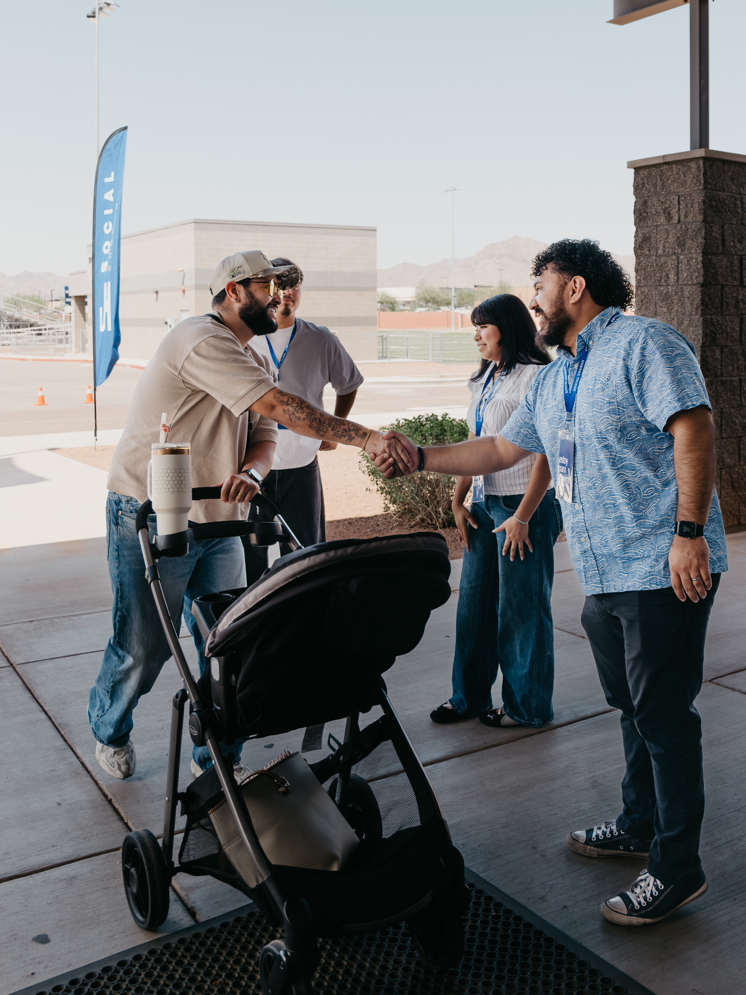 A family with a stroller being welcomed to Social Church.